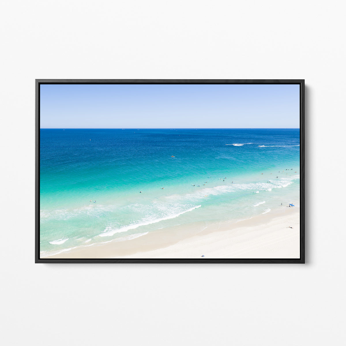 Black framed canvas print of aerial photography of Scarborough Beach, deep blue water, turquoise shallows and pale sand along a diagonal shore