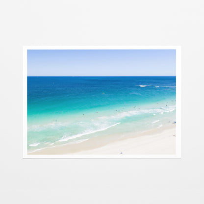 Fine art paper print of aerial photography of Scarborough Beach, deep blue water, turquoise shallows and pale sand along a diagonal shore with a white border