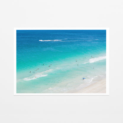 Fine art paper print of aerial photography of Scarborough Beach, surfers in blue and turquoise water along a diagonal shoreline with white foam lines with a white border