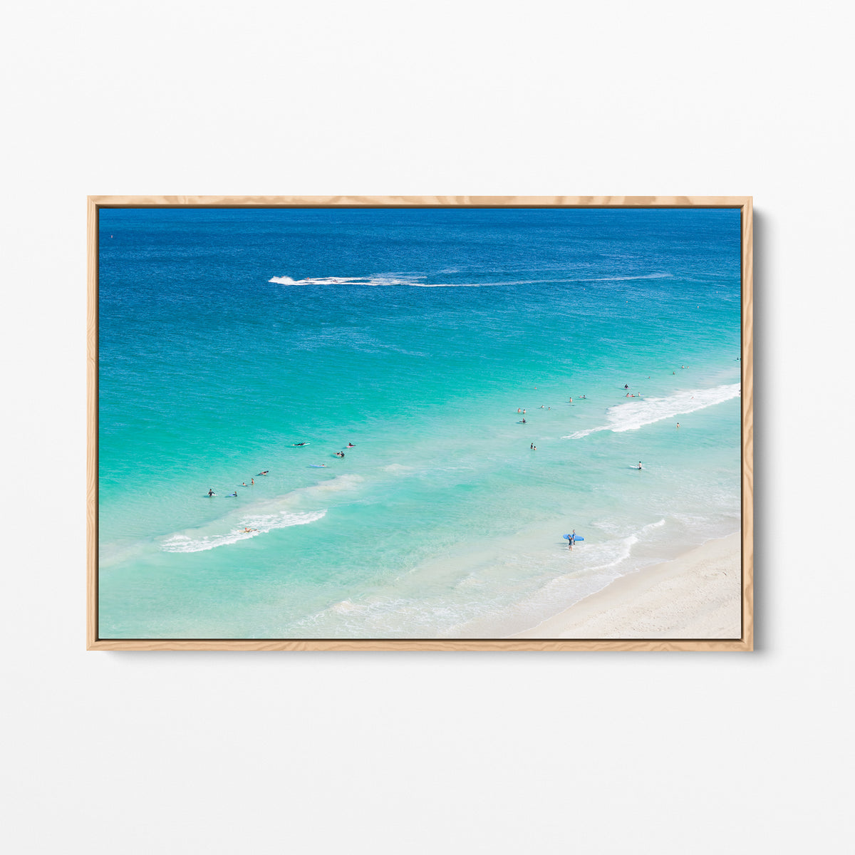 Oak framed canvas print of aerial photography of Scarborough Beach, surfers in blue and turquoise water along a diagonal shoreline with white foam lines