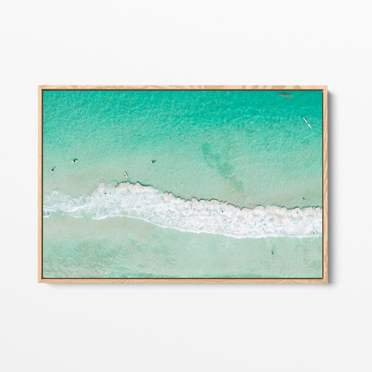 Oak framed canvas print of aerial photography of Scarborough Beach, a line of white wave across green turquoise shallows with shadows on the sea floor