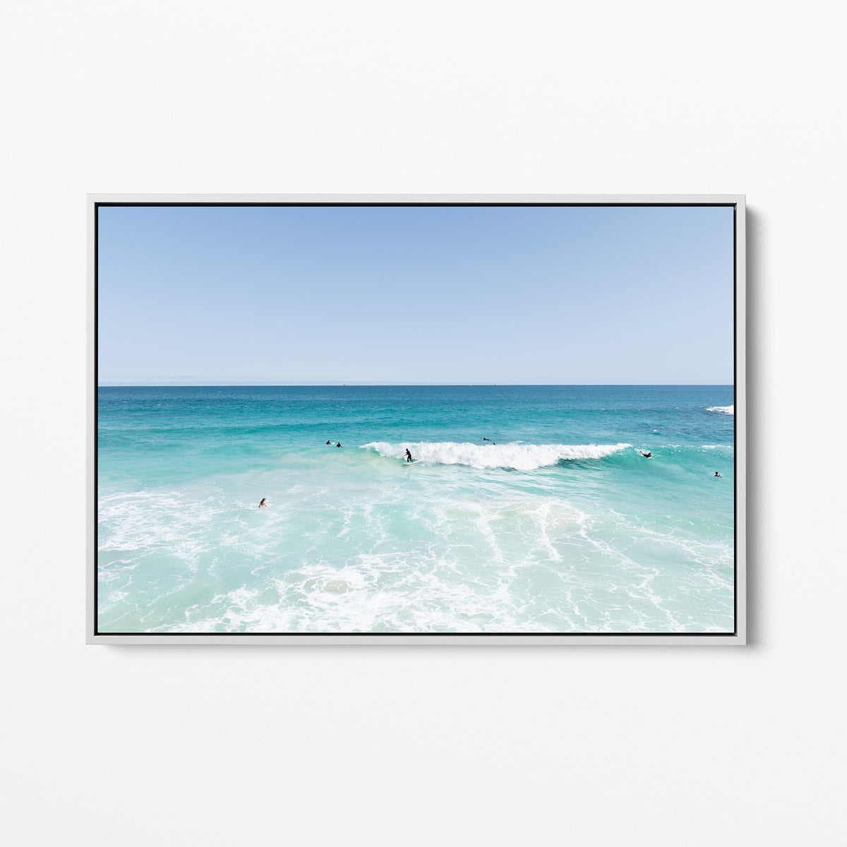 White framed canvas print of aerial photography of Scarborough Beach, surfers waiting beside a small breaking wave in turquoise water