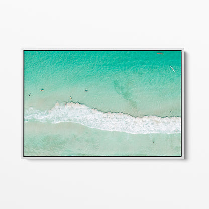 White framed canvas print of aerial photography of Scarborough Beach, a line of white wave across green turquoise shallows with shadows on the sea floor