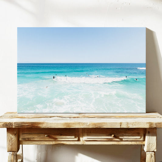 Stretched canvas print of aerial photography of Scarborough Beach, a wide view of surfers spread across turquoise water and white foam on a console table