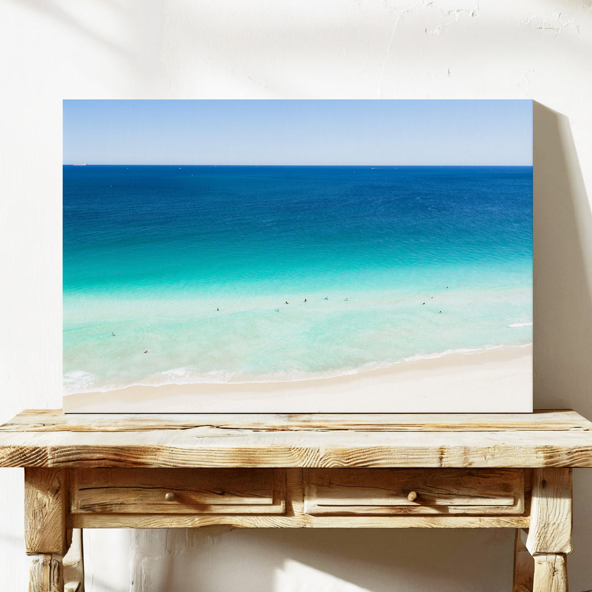 Stretched canvas print of aerial photography of Scarborough Beach, dark blue ocean, a turquoise band of shallows and pale sand on a console table