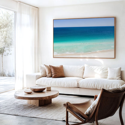 Canvas print of aerial photography of Scarborough Beach, dark blue ocean, a turquoise band of shallows and pale sand hanging above a sofa in a living room