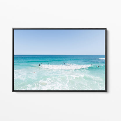 Black framed canvas print of aerial photography of Scarborough Beach, a wide view of surfers spread across turquoise water and white foam